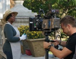 Cameraman films a woman in gardening.