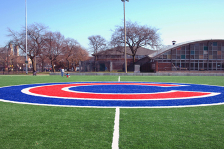Green turf field with a large Cubs logo at center.