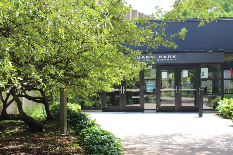 Entrance to Duane Park fieldhouse with lush green trees.