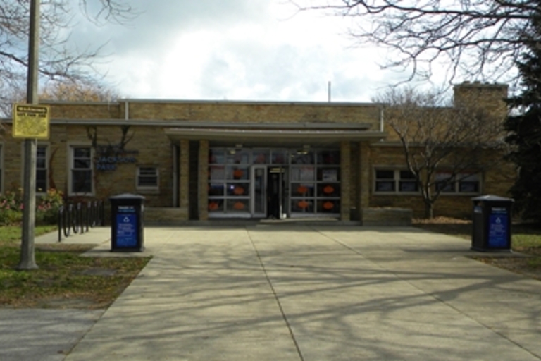 One-story brick building with glass double doors and columns.