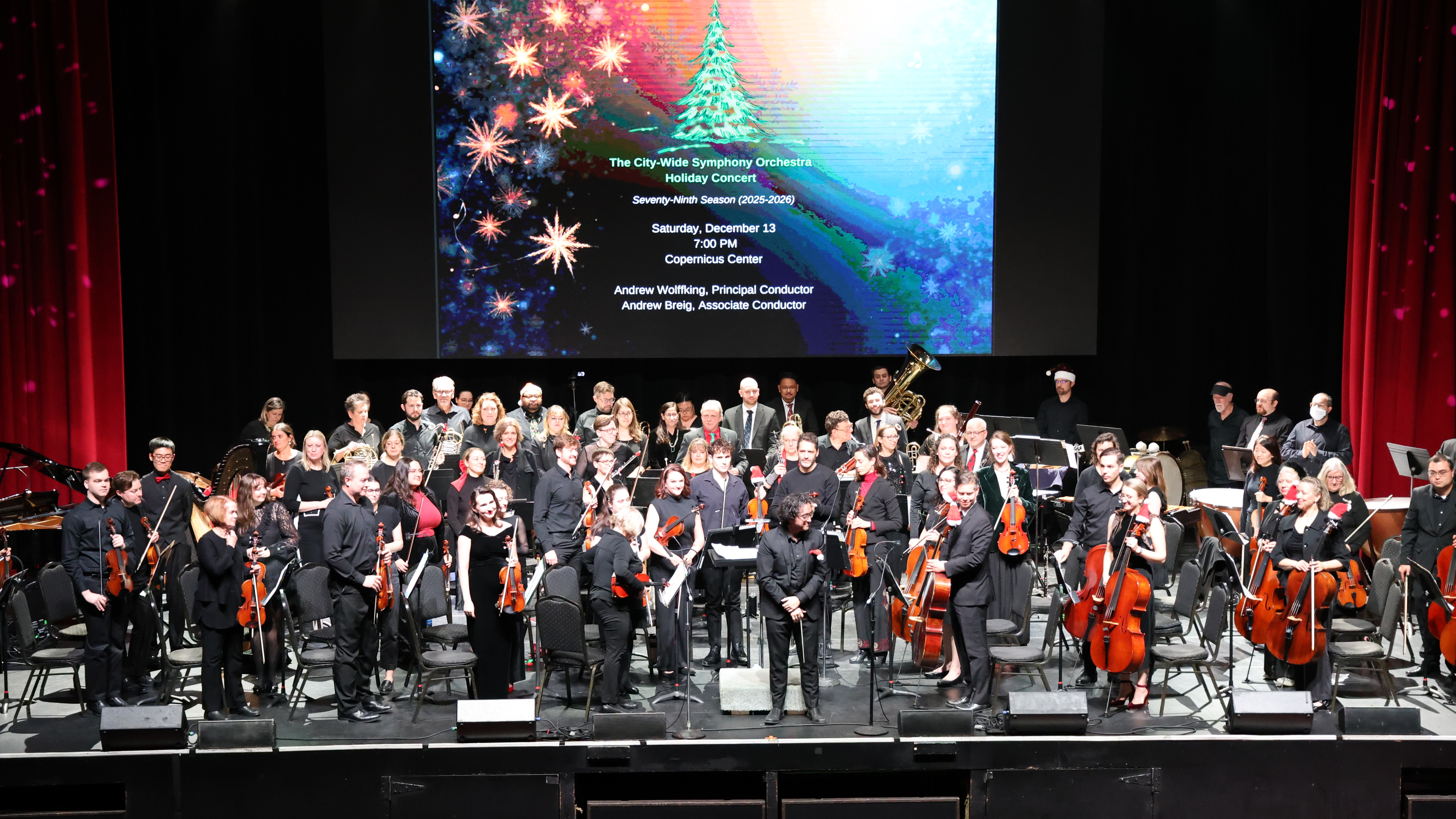Orchestra performs a holiday concert on stage.