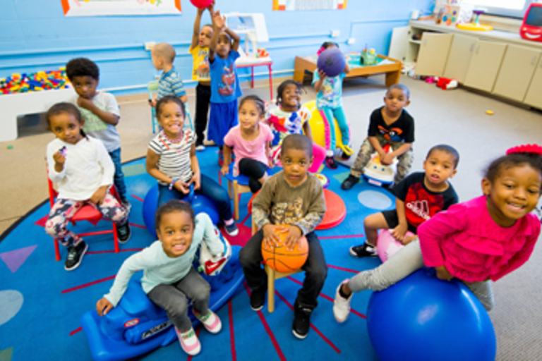 Children playing on toys in a daycare center.
