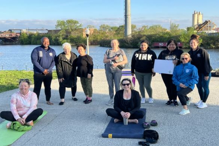 Group photo of people in athletic wear by a river after a yoga class.