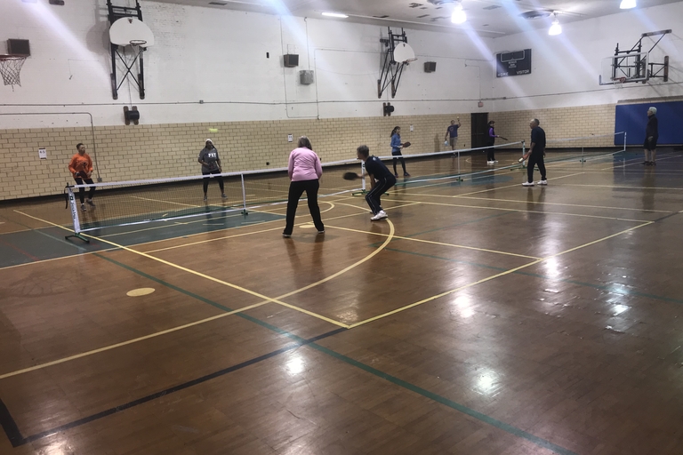 People playing pickleball in a gym.