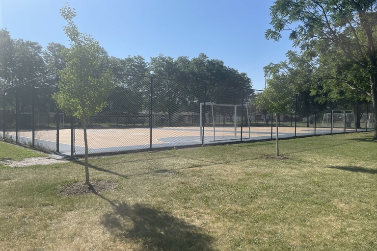 Fenced-in sports court on a sunny day.