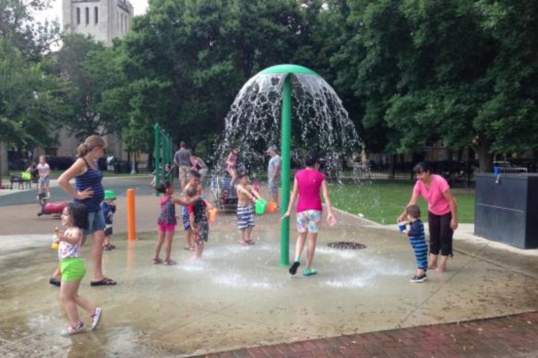 Children play in a splash pad on a summer day.