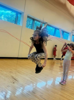 Girl jumping rope in a gym.