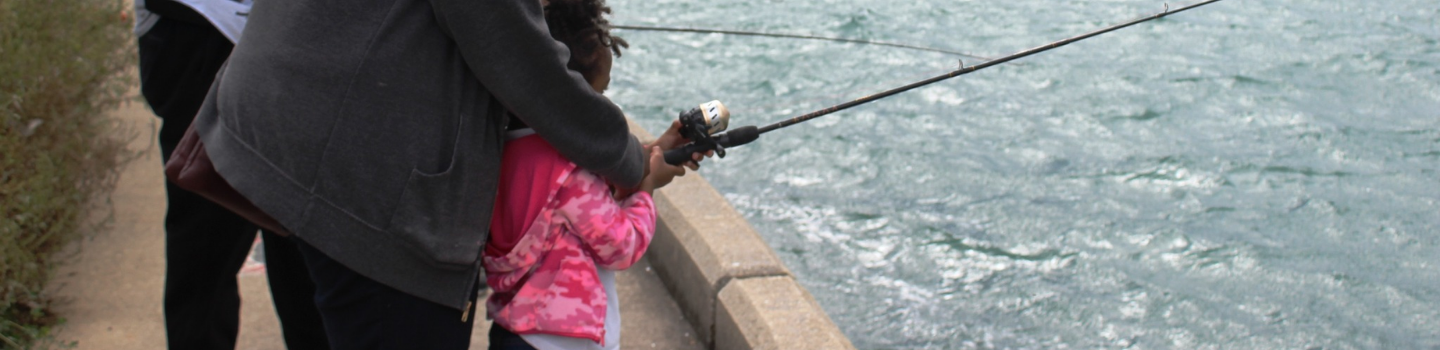 Adult and child fishing from a pier.