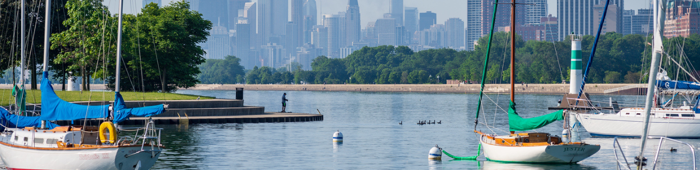 Sailboats moored in a harbor, Chicago skyline in the distance.