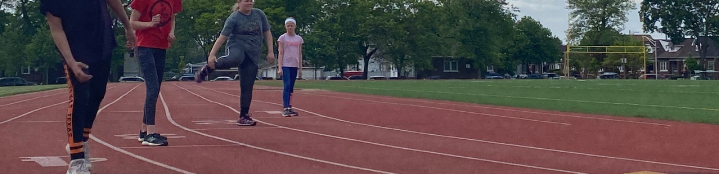Kids stretching on a red running track.