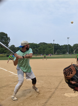 Batter swings at a softball during a game.