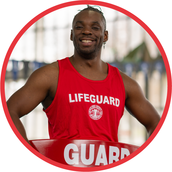 Uniformed lifeguard stands proudly with a pool in the background.
