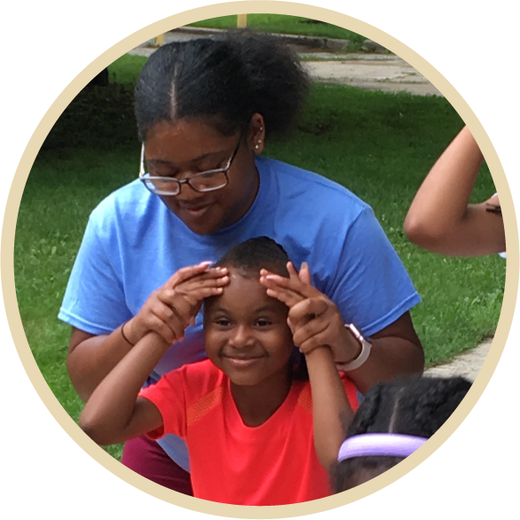 A Special Recreation Leader plays with a smiling camper outdoor at a park.